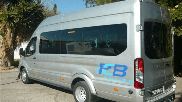 Silver tour van parked outdoors with 'P2B Tours' logo on the side.