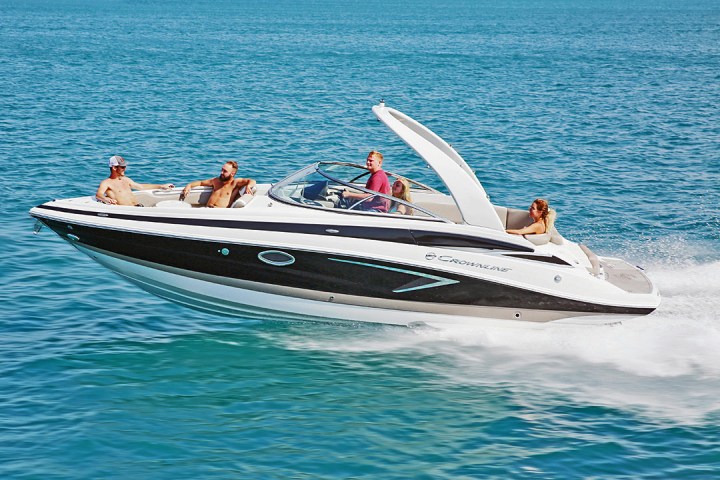 Four people enjoying a speedboat ride on clear blue water.